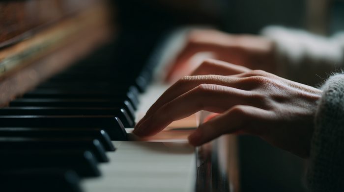 Close-up of hands demonstrating proper piano technique during lesson