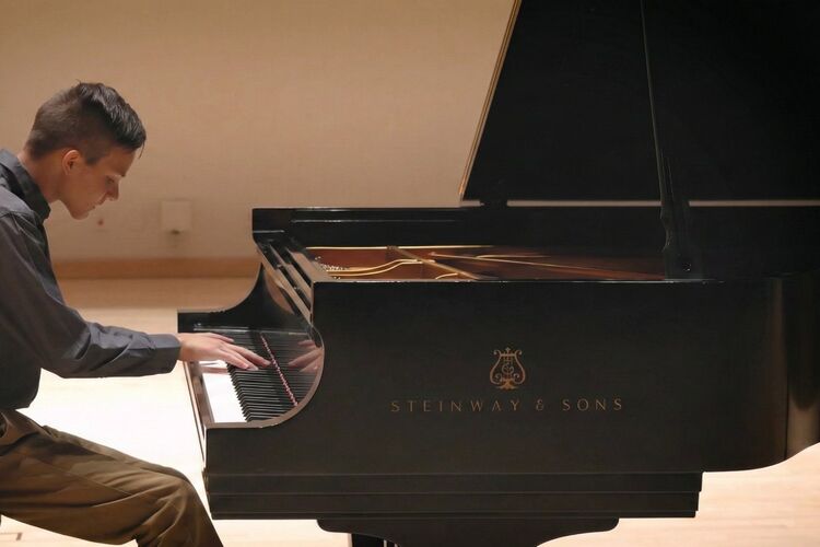 Piano student performing at recital on a Steinway concert grand